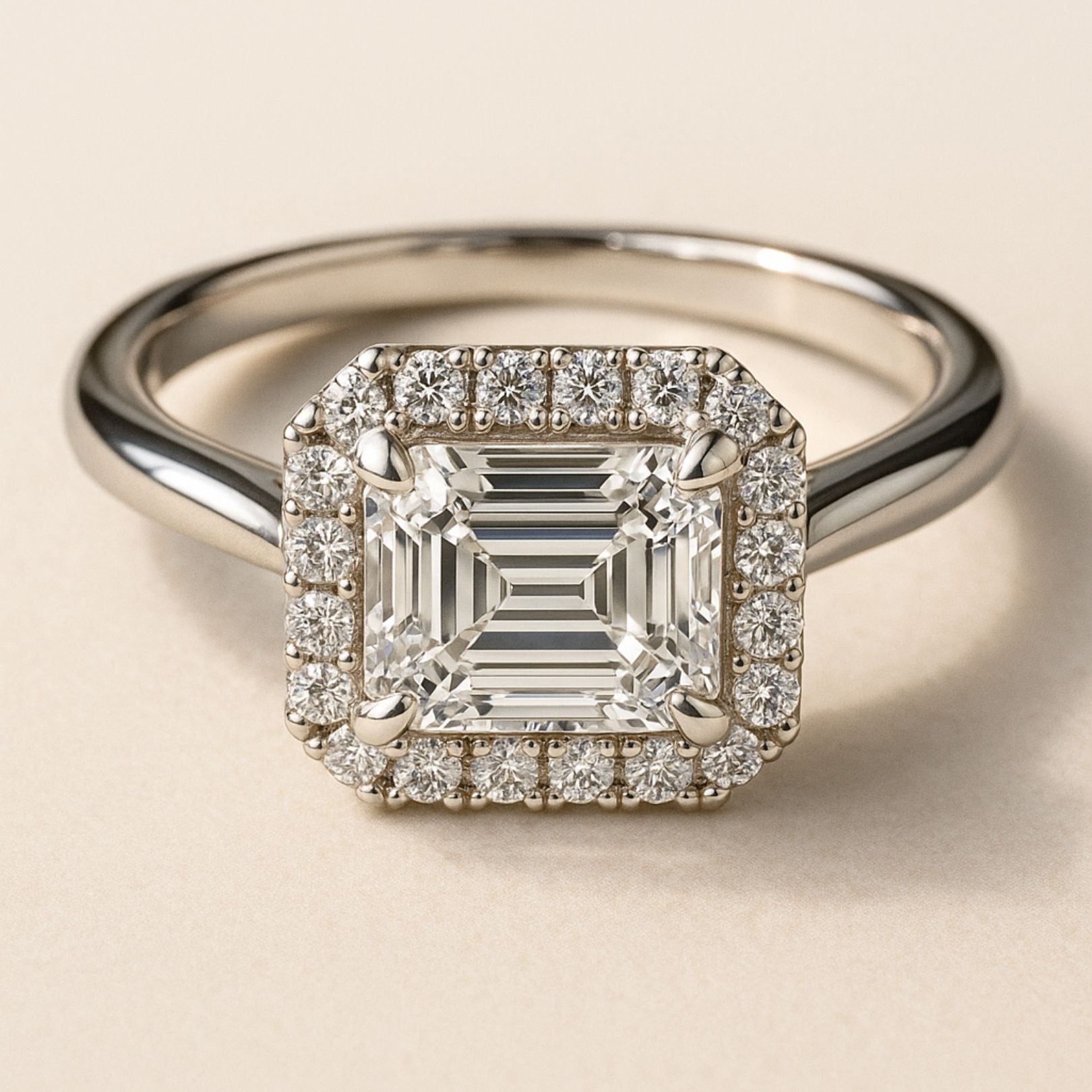 white gold engagement ring, emerald cut diamond ring, halo engagement ring, handmade wedding ring, ethical diamond ring, modern bridal jewelry, geometric engagement ring, handcrafted England ring, sustainable wedding band, anniversary gift, luxury engagement ring, contemporary bridal ring, elegant diamond ring