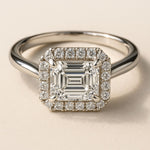 white gold engagement ring, emerald cut diamond ring, halo engagement ring, handmade wedding ring, ethical diamond ring, modern bridal jewelry, geometric engagement ring, handcrafted England ring, sustainable wedding band, anniversary gift, luxury engagement ring, contemporary bridal ring, elegant diamond ring