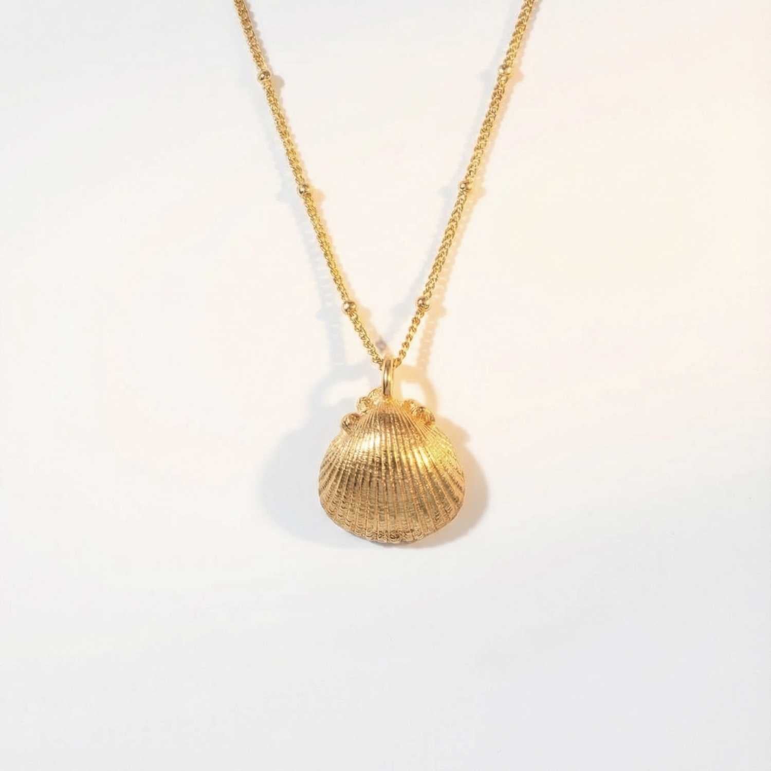Solid Gold Seashell Necklace for Lovers of the Sea - Dainty London gold seashell necklace, coastal jewelry, ocean pendant, nature inspired jewelry, Cornwall seaside gift, beach lover gift, mermaid jewelry, ocean lover necklace, handmade coastal jewelry, star charm necklace, sustainable jewelry, beach cottage style, meaningful coastal gift