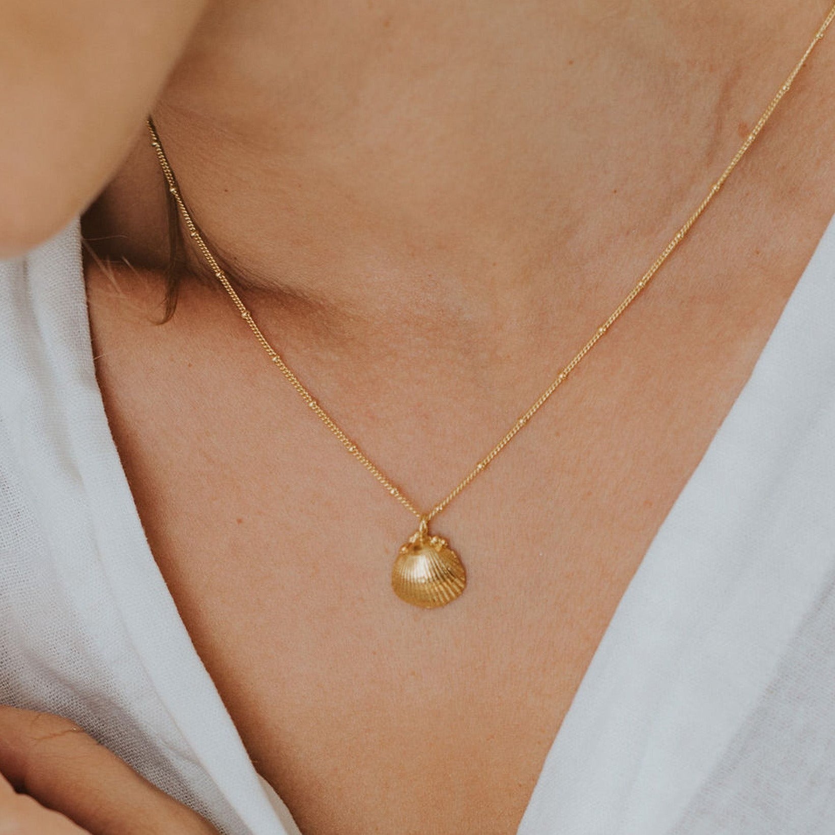 Solid Gold Seashell Necklace for Lovers of the Sea - Dainty London gold seashell necklace, coastal jewelry, ocean pendant, nature inspired jewelry, Cornwall seaside gift, beach lover gift, mermaid jewelry, ocean lover necklace, handmade coastal jewelry, star charm necklace, sustainable jewelry, beach cottage style, meaningful coastal gift