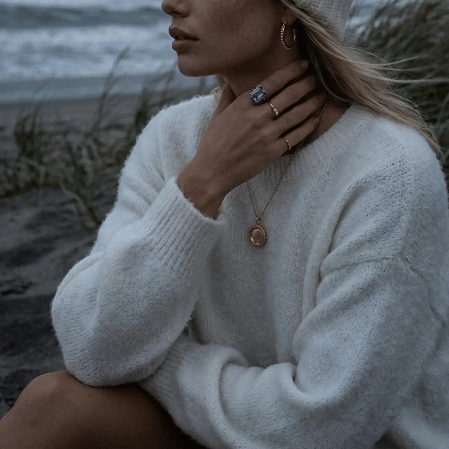 The Mermaid's Coin - a 2cm round gold disc pendant featuring a bold seashell motif and the Latin inscription 'Fluctuat nec mergitur', handcrafted by Dainty London.
