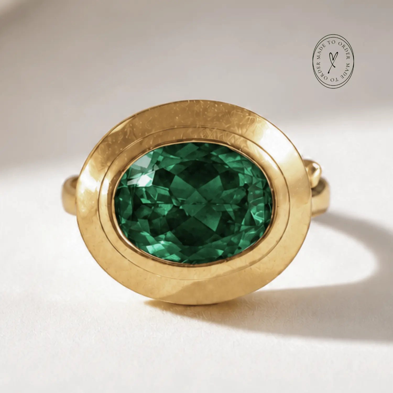 Sylvie solid 9ct gold green emerald ring with 10x8mm oval cut stone and granulation detail, handcrafted luxury fine jewellery by Dainty London

