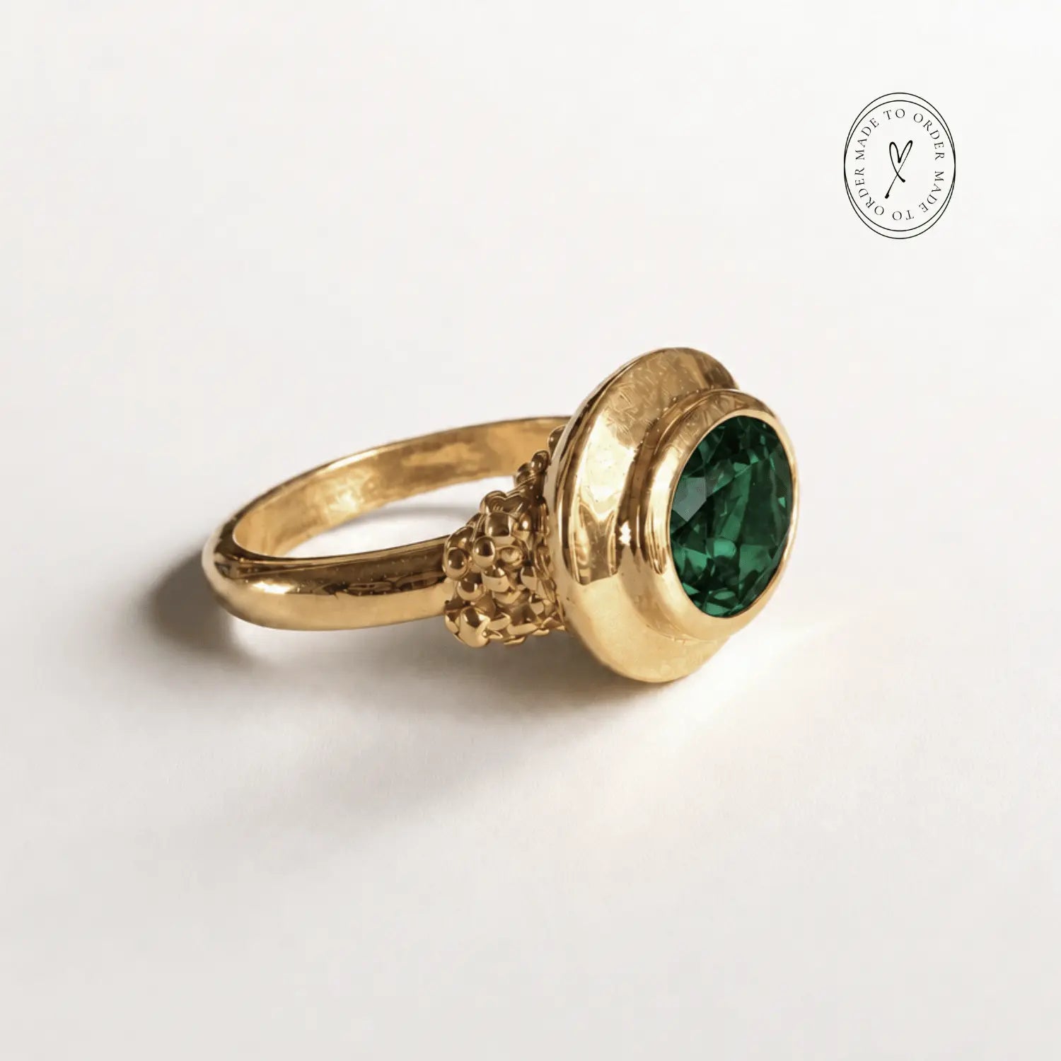 Sylvie solid 9ct gold green emerald ring with 10x8mm oval cut stone and granulation detail, handcrafted luxury fine jewellery by Dainty London